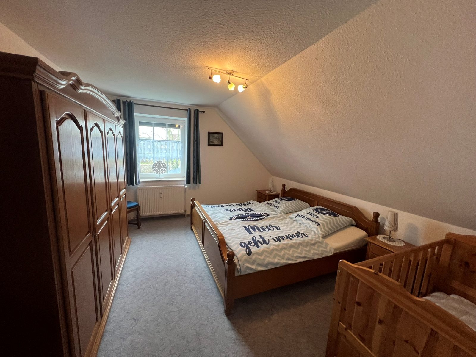 Schlafzimmer mit Kleiderschrank und Reisebett