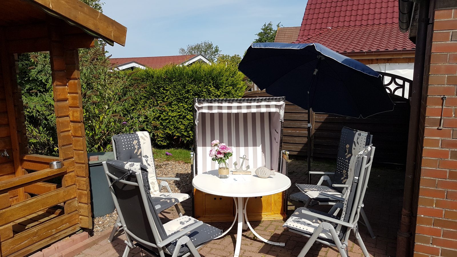 Strandkorb und Sonnenschirm auf der Terrasse