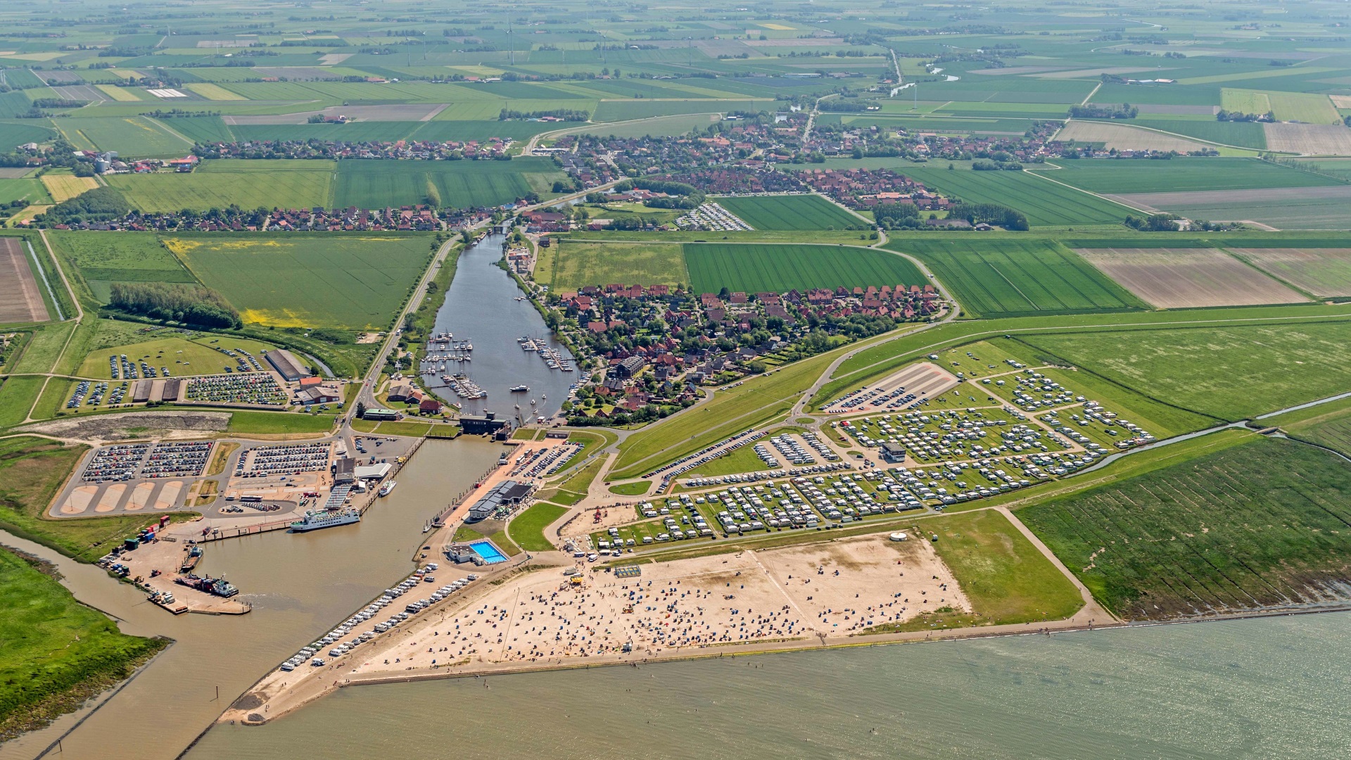 Luftaufnahme von Harlesiel mit Hafen, Strand und Wohnmobilstellplatz