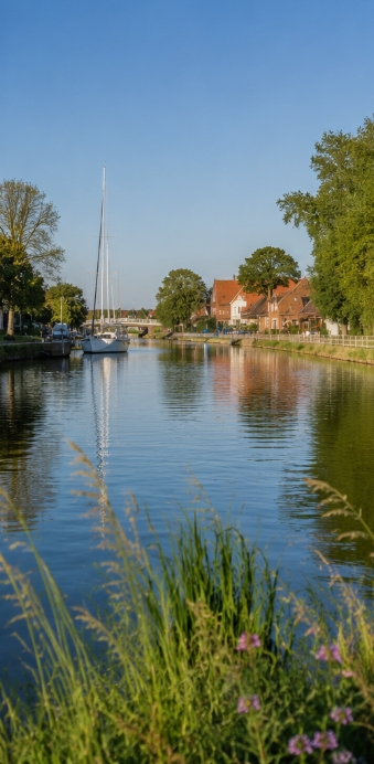 Die Harle mit Segelboot und Häusern am Ufer