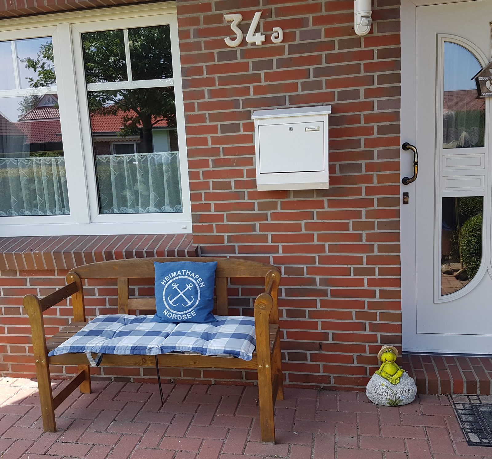 Hauseingang mit Sitzbank im Sommer